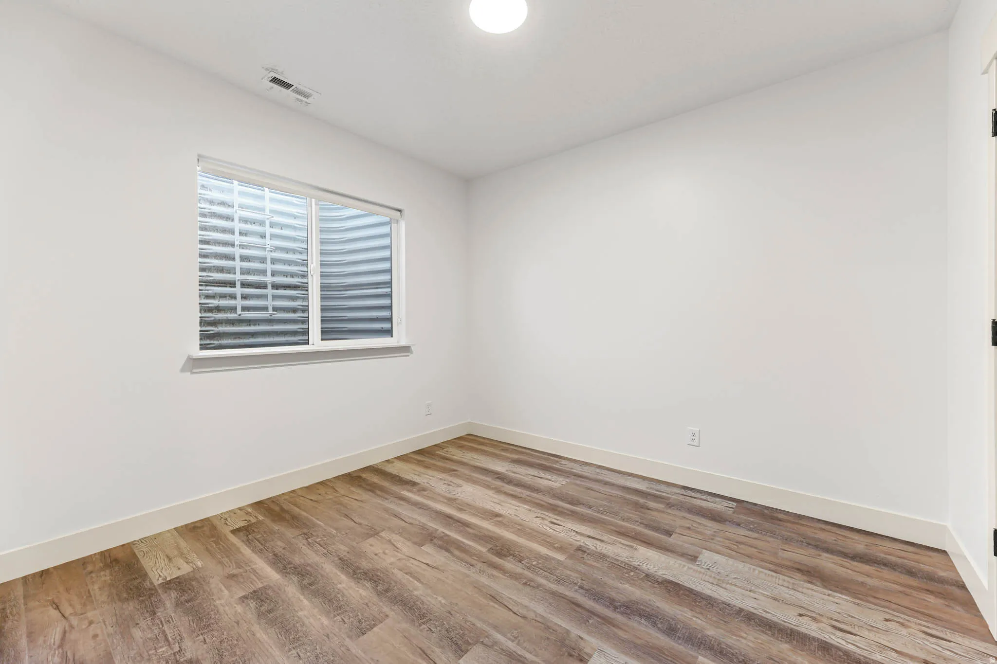 Unfurnished room featuring light wood-style flooring and baseboards