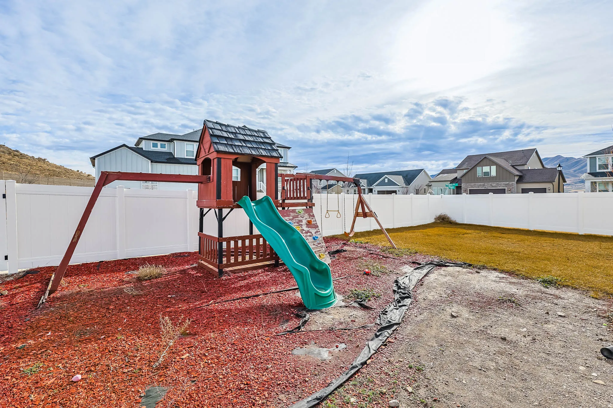 View of playground with a fenced backyard and a residential view
