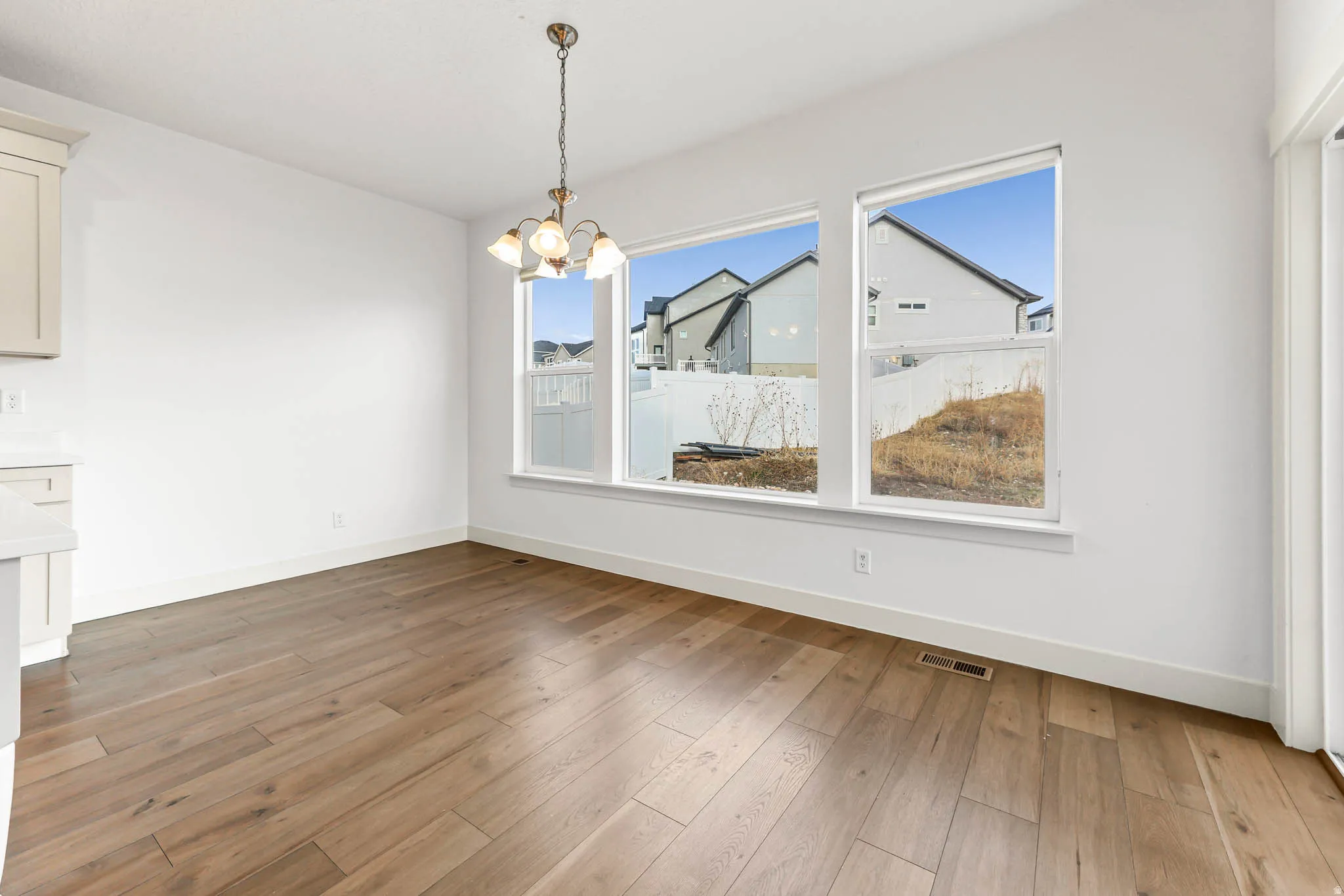 Unfurnished dining area with a chandelier and light wood-style floors