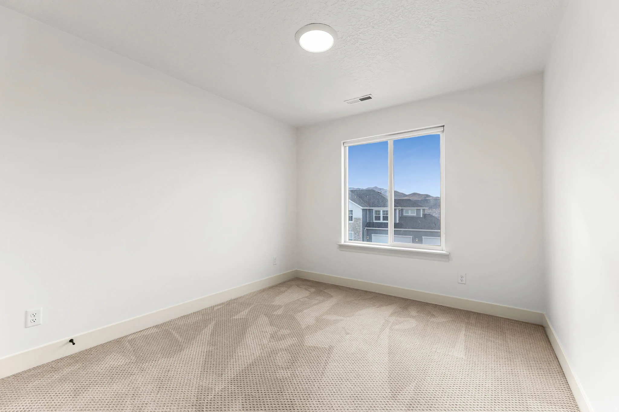Spare room with light carpet and a textured ceiling