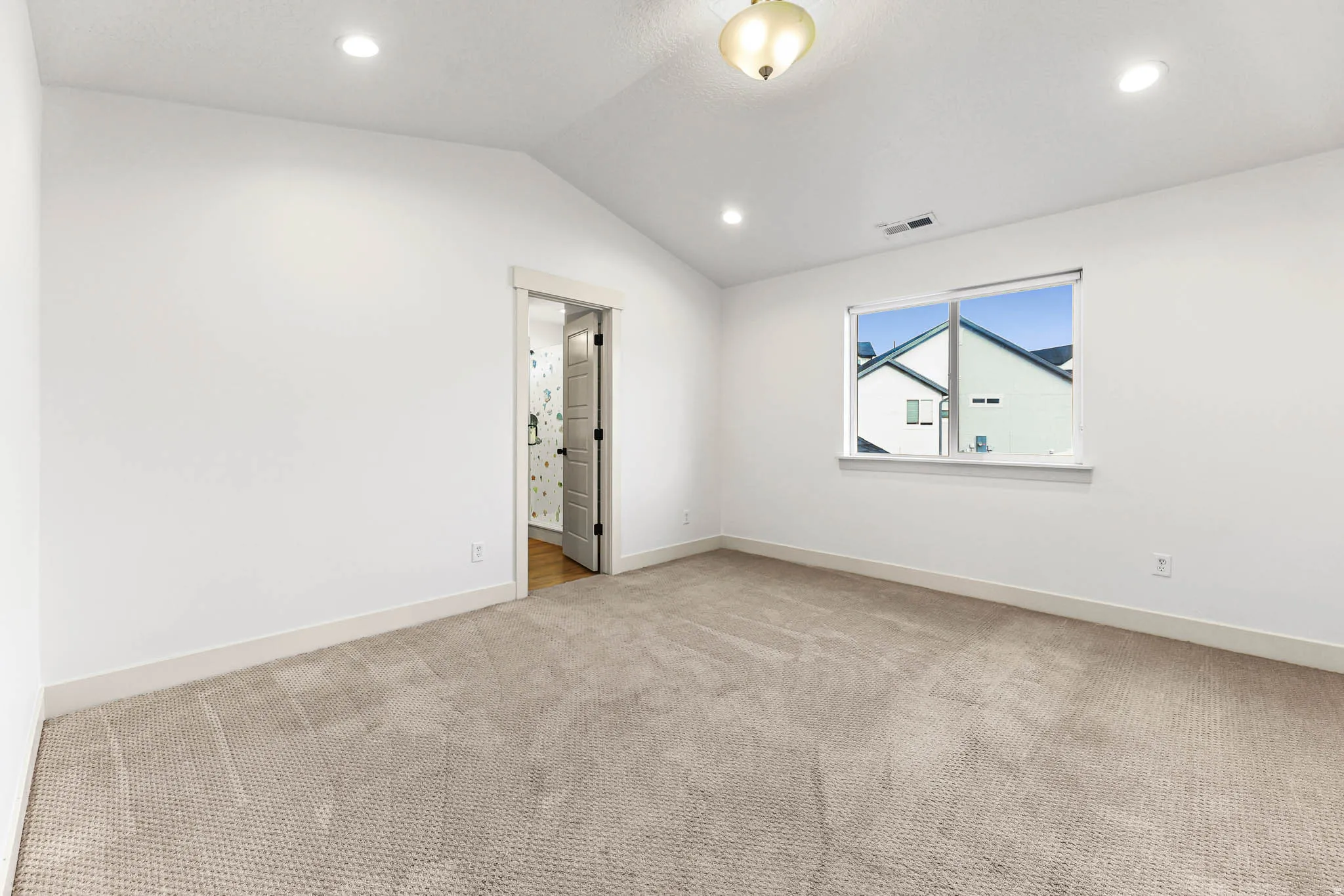 Spare room with vaulted ceiling, recessed lighting, and light colored carpet