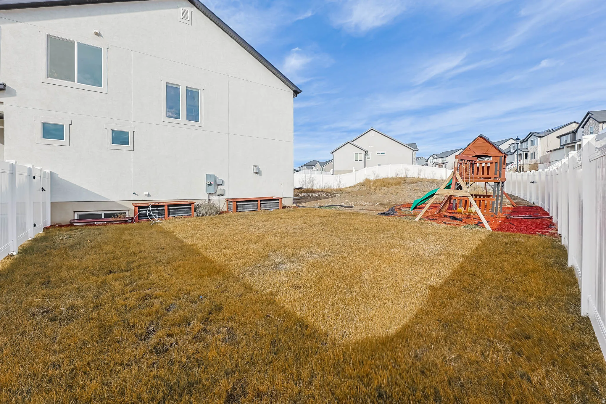 Fenced backyard with a playground and a residential view