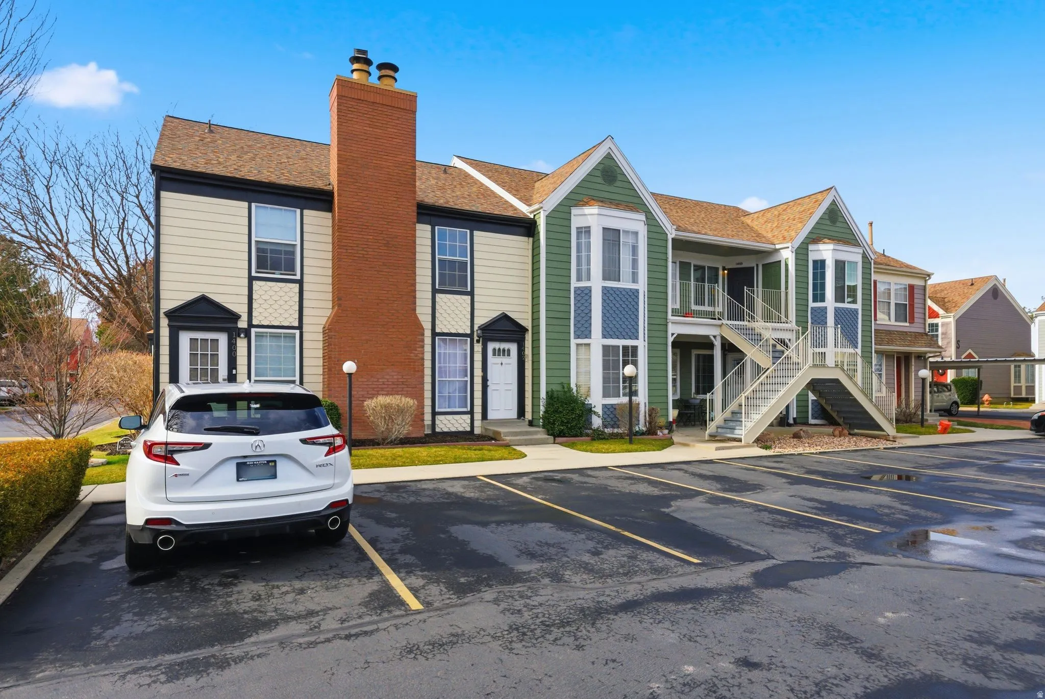 View of building exterior with uncovered parking, stairs, and a residential view