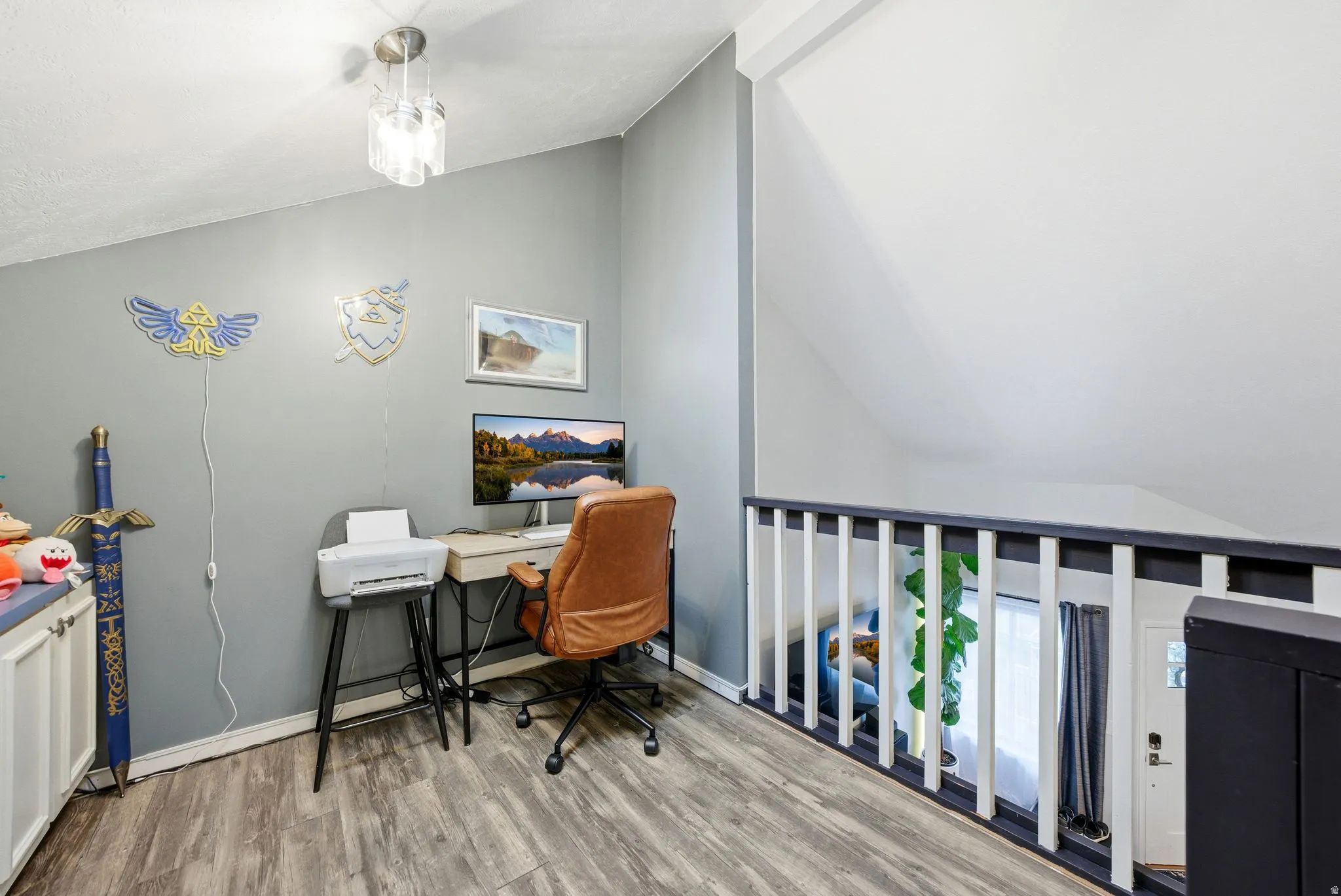 Home office with vaulted ceiling and wood finished floors