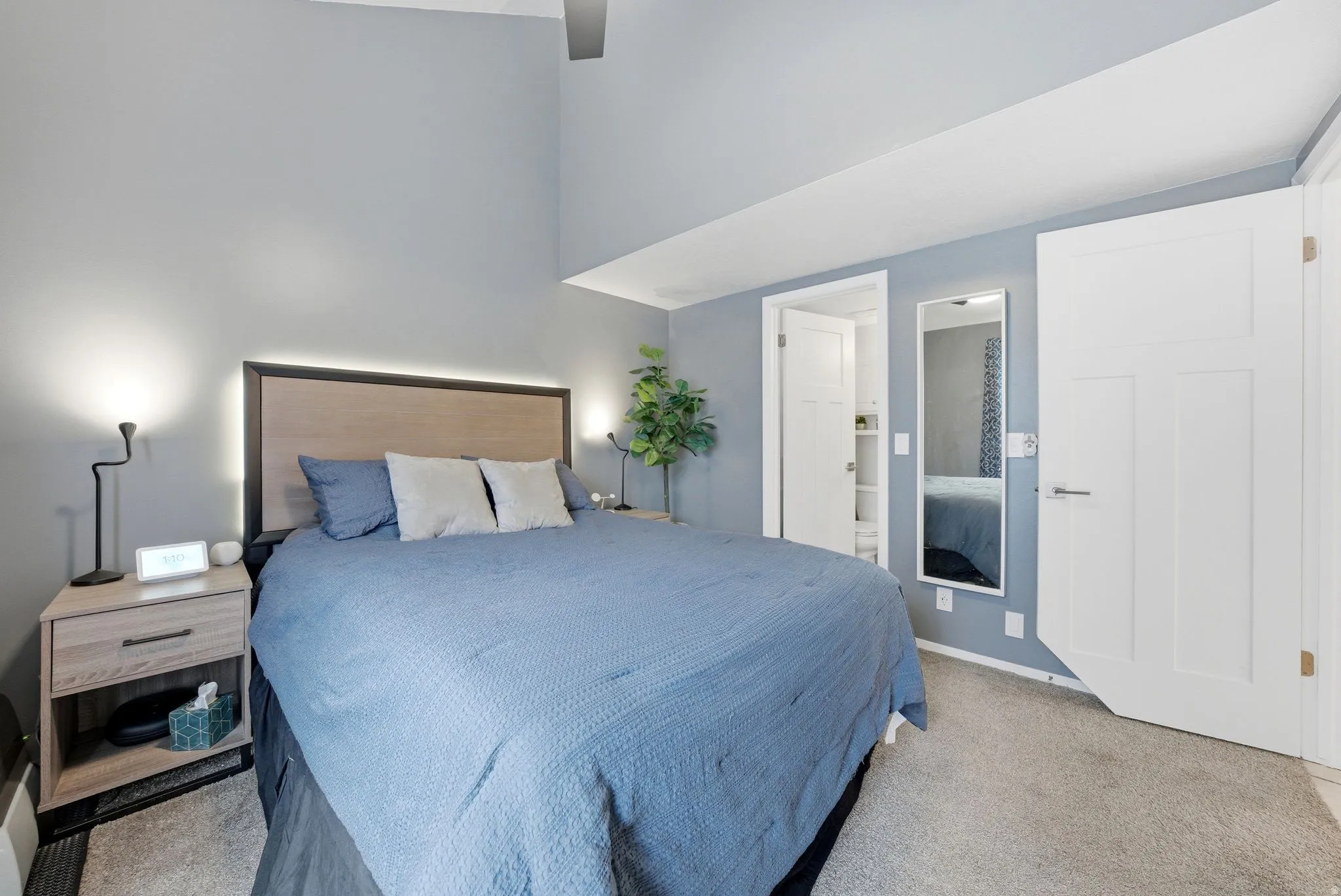 Bedroom featuring light carpet, ceiling fan, and ensuite bath