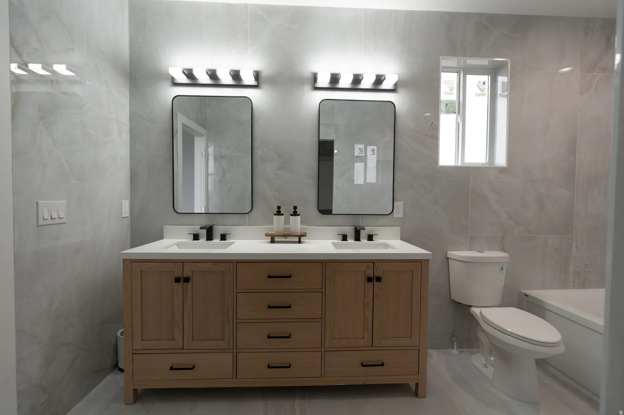 Bathroom with double vanity and tile walls