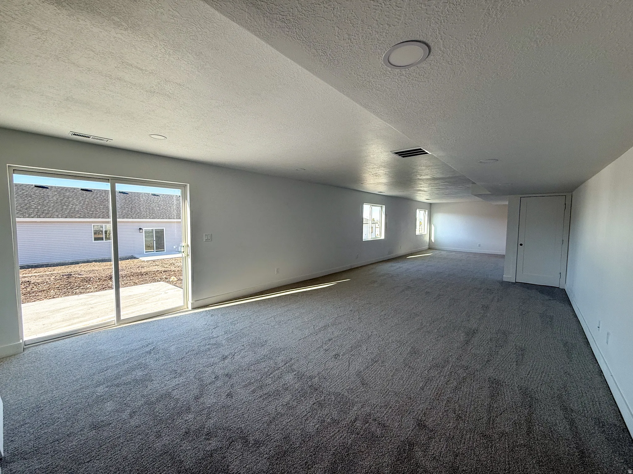 Carpeted empty room featuring a textured ceiling