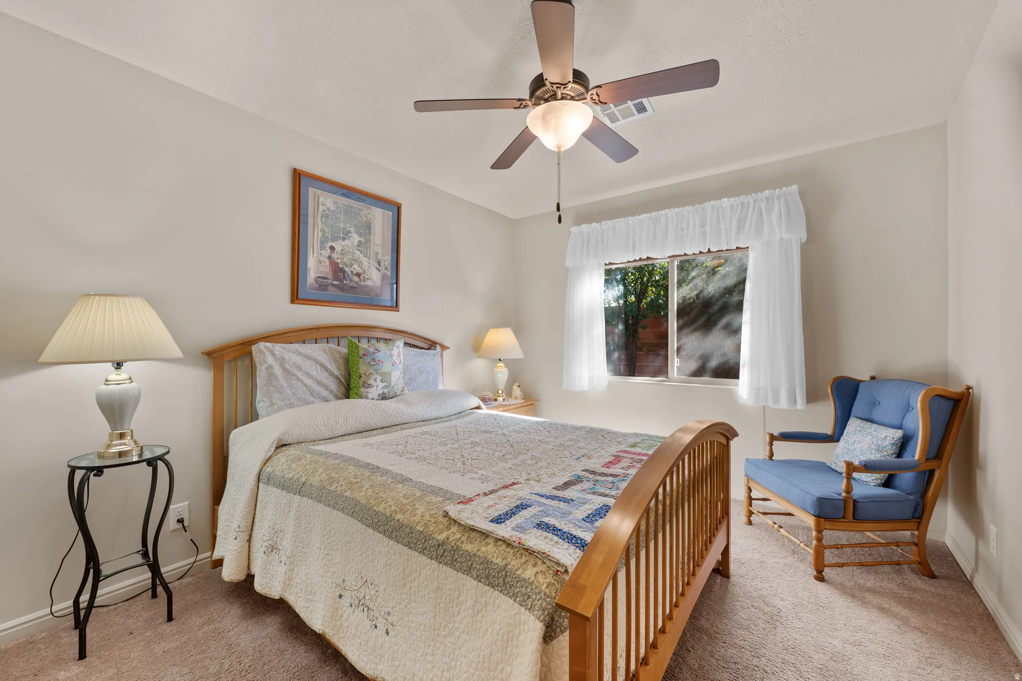 Carpeted bedroom featuring ceiling fan and baseboards