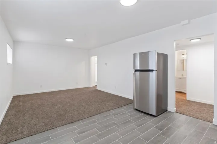 Empty room featuring baseboards and light carpet