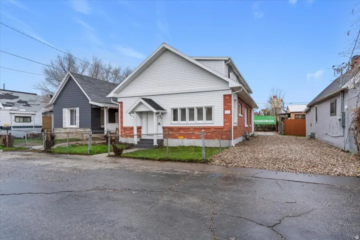 Bungalow with a fenced front yard, brick siding, and a gate