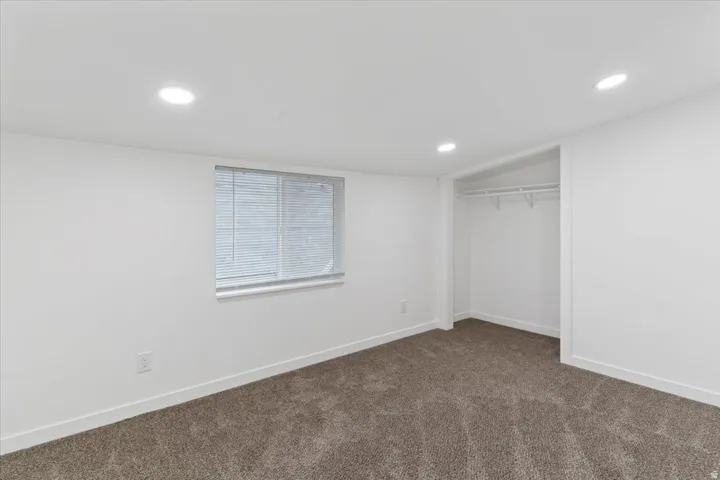 Unfurnished bedroom featuring carpet, recessed lighting, and a closet
