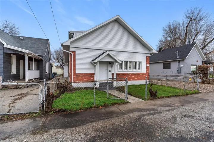 Bungalow with brick siding, a gate, and a fenced front yard