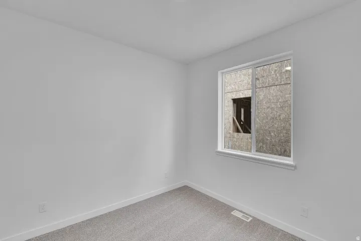 Unfurnished room with carpet flooring and baseboards
