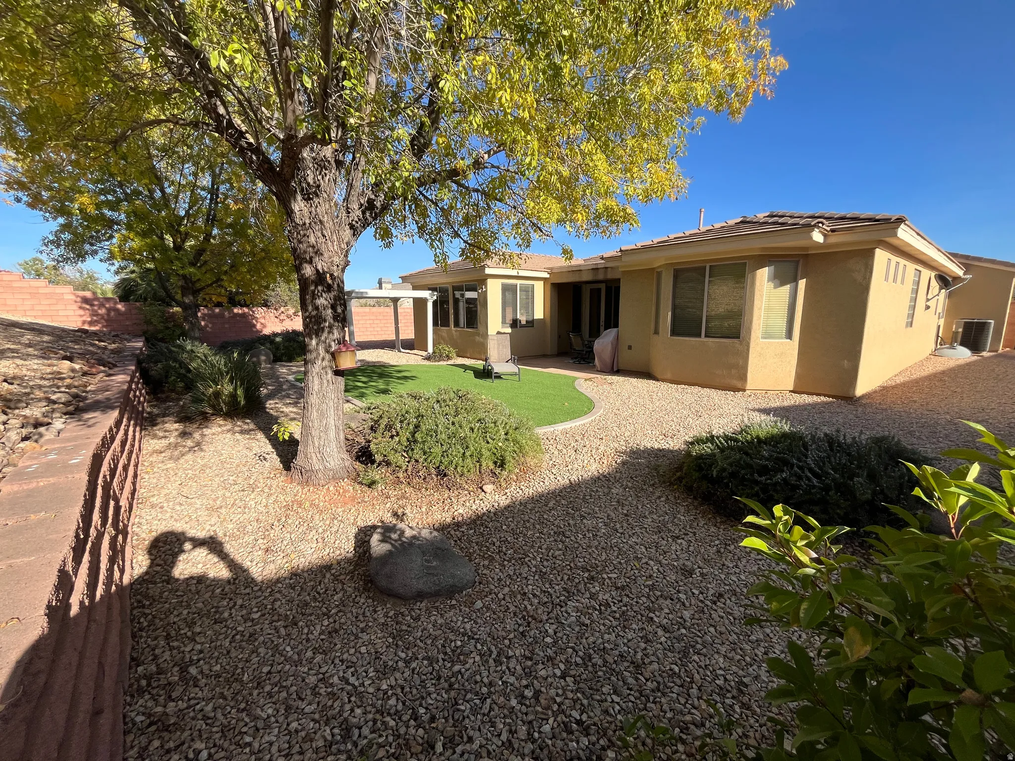 Rear view of house with a fenced backyard, stucco siding, and a patio area