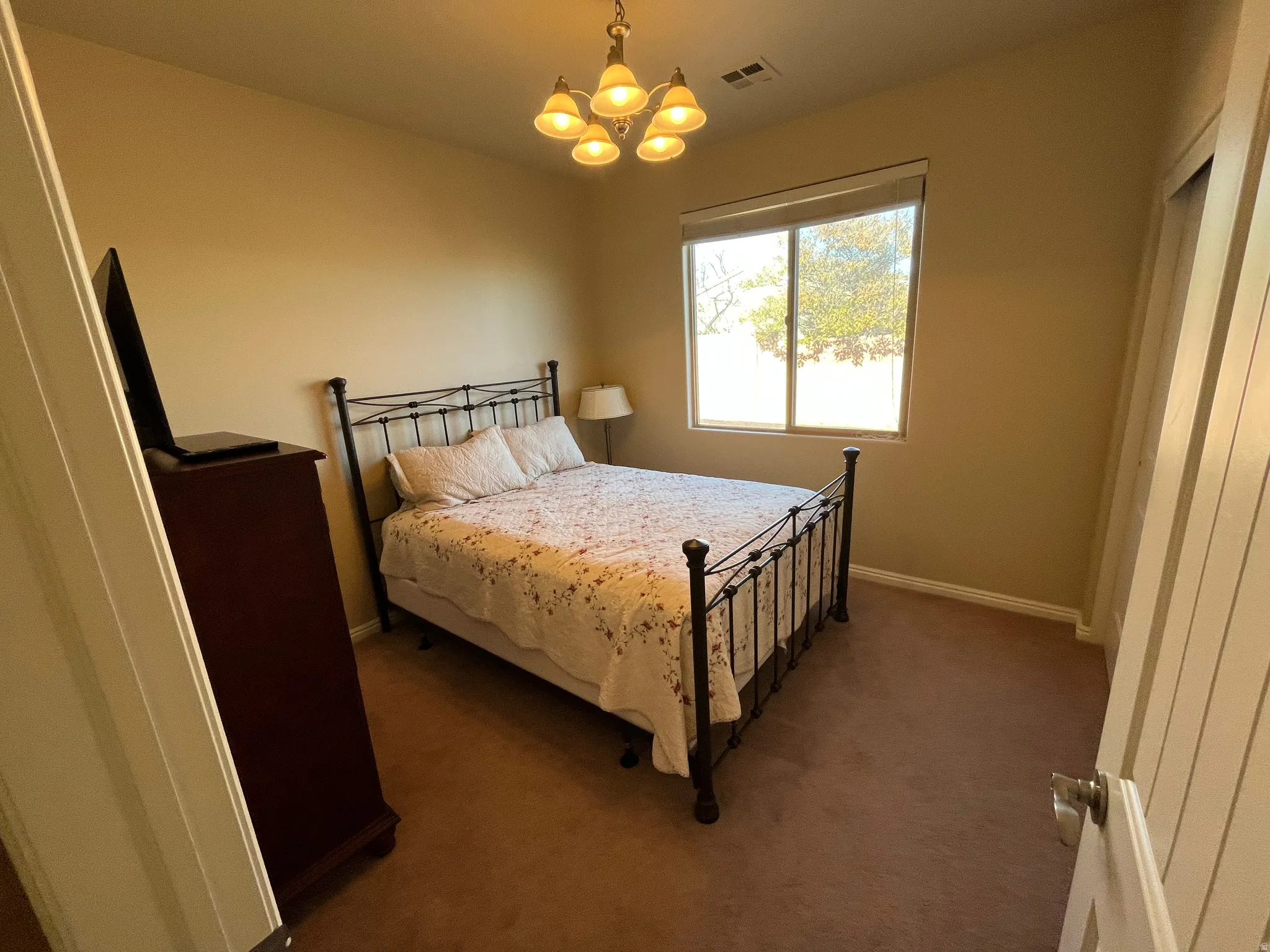 Bedroom with carpet flooring and a chandelier