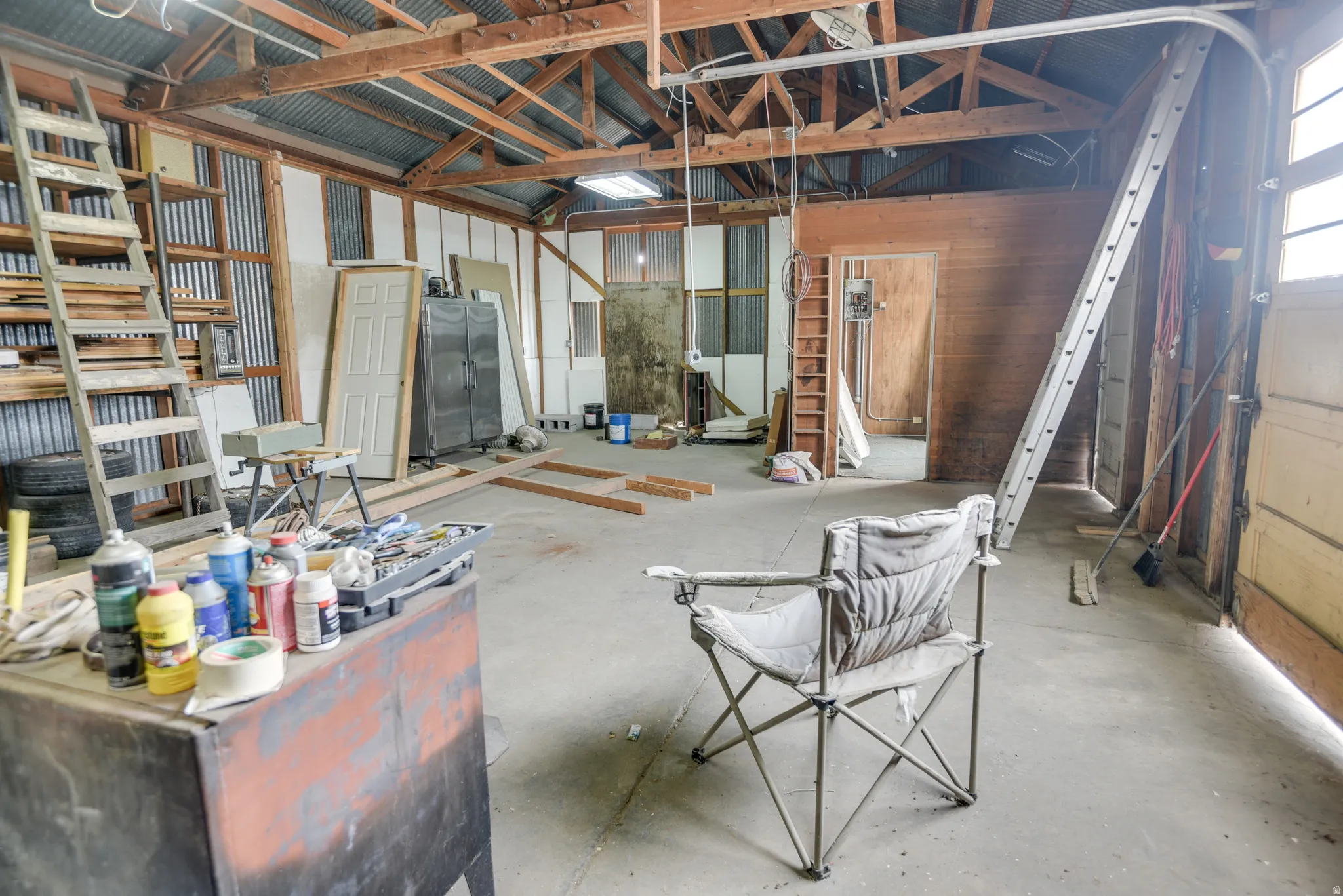 Miscellaneous room featuring vaulted ceiling and unfinished concrete floors