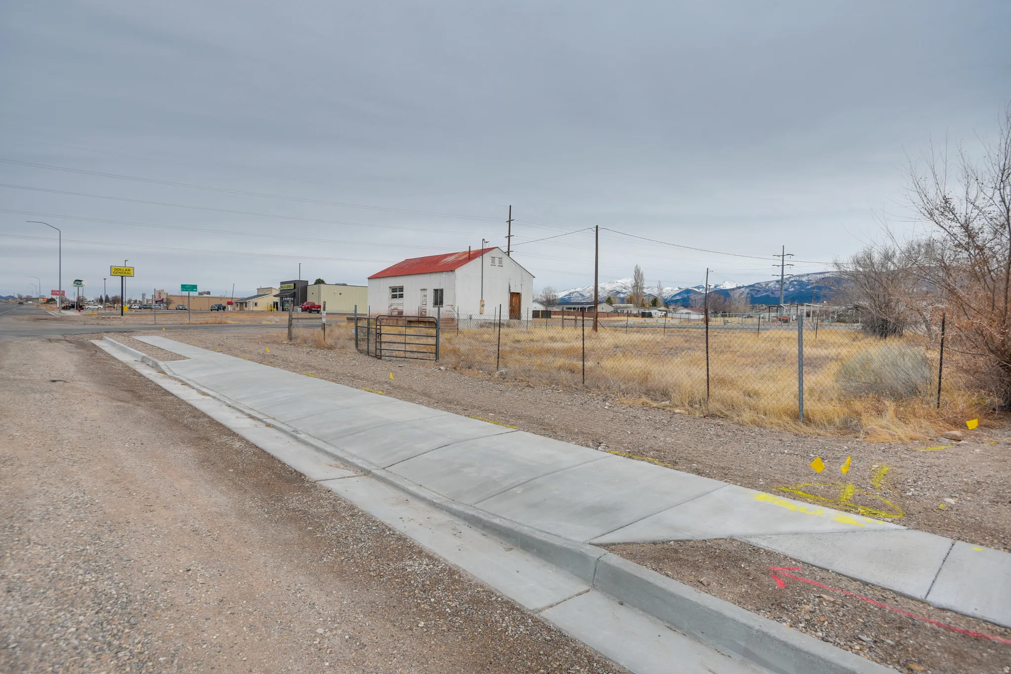 View of asphalt street with sidewalks, curbs, and street lights