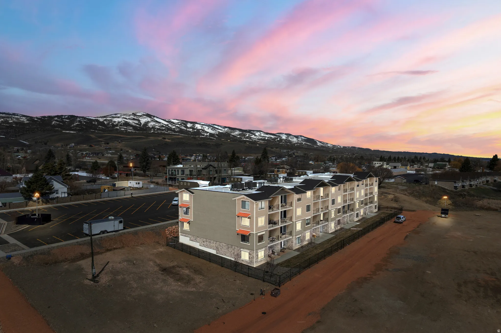 Aerial view at dusk of a view of apartment building / complex and a mountain view