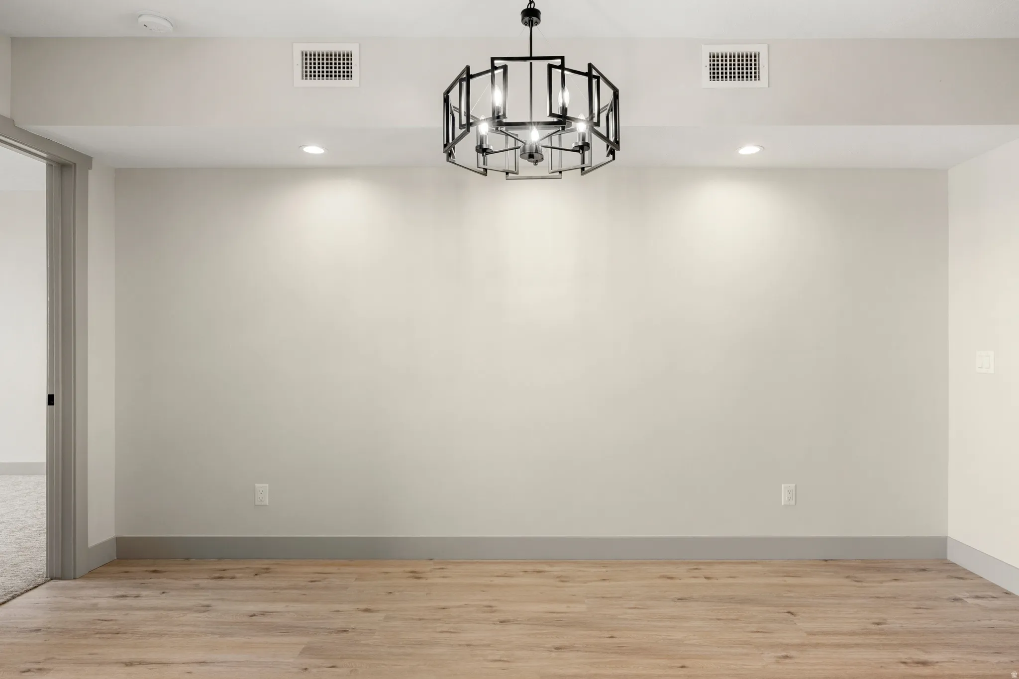 Unfurnished dining area with a chandelier, recessed lighting, and light wood finished floors