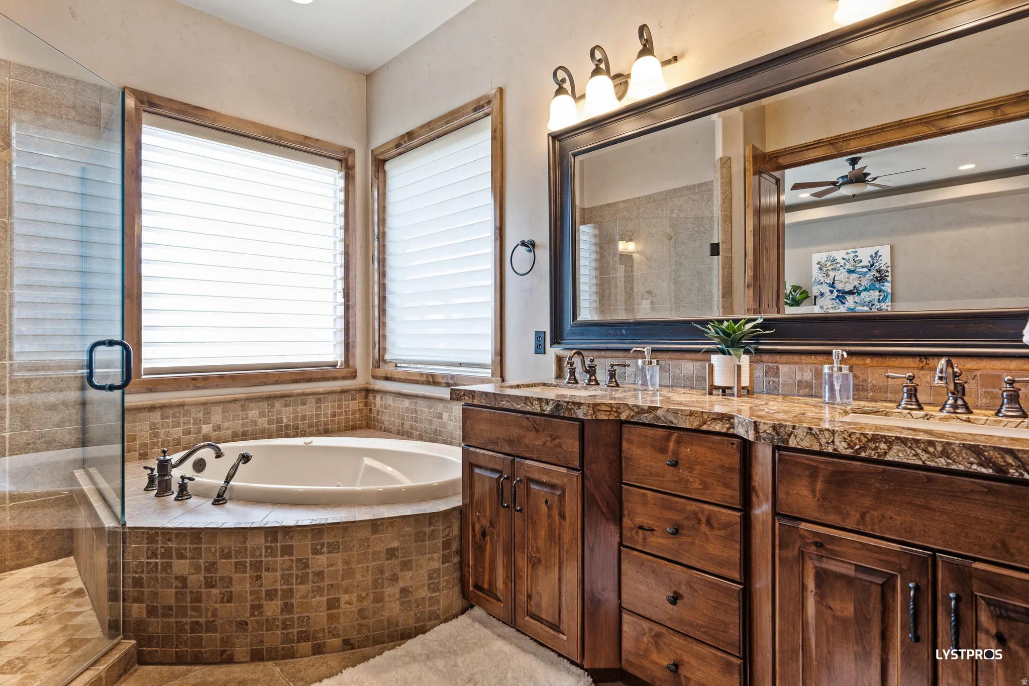 Bathroom featuring double vanity, a garden tub, a shower stall, a ceiling fan, and recessed lighting