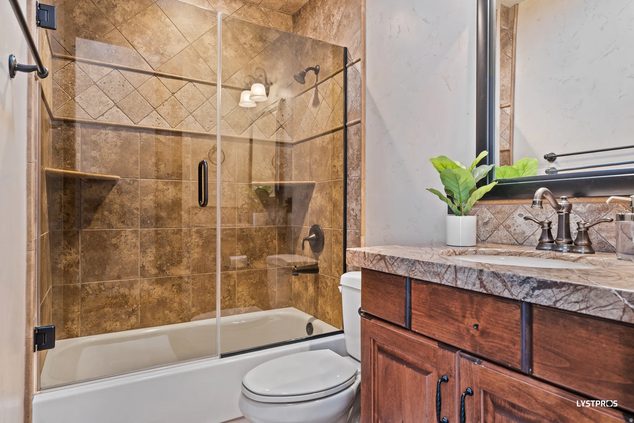 Bathroom featuring vanity and combined bath / shower with glass door