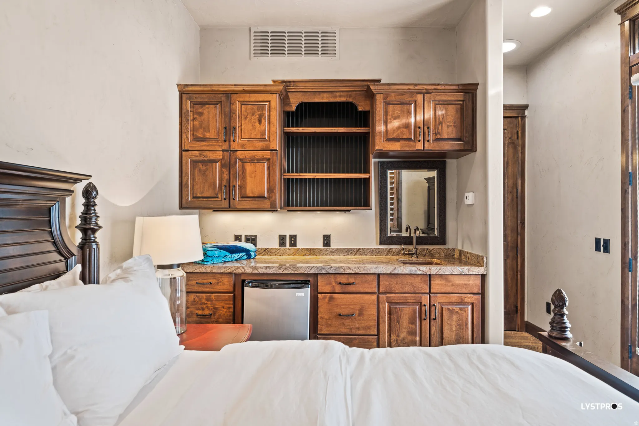 Kitchen featuring brown cabinetry, open shelves, and stainless steel dishwasher