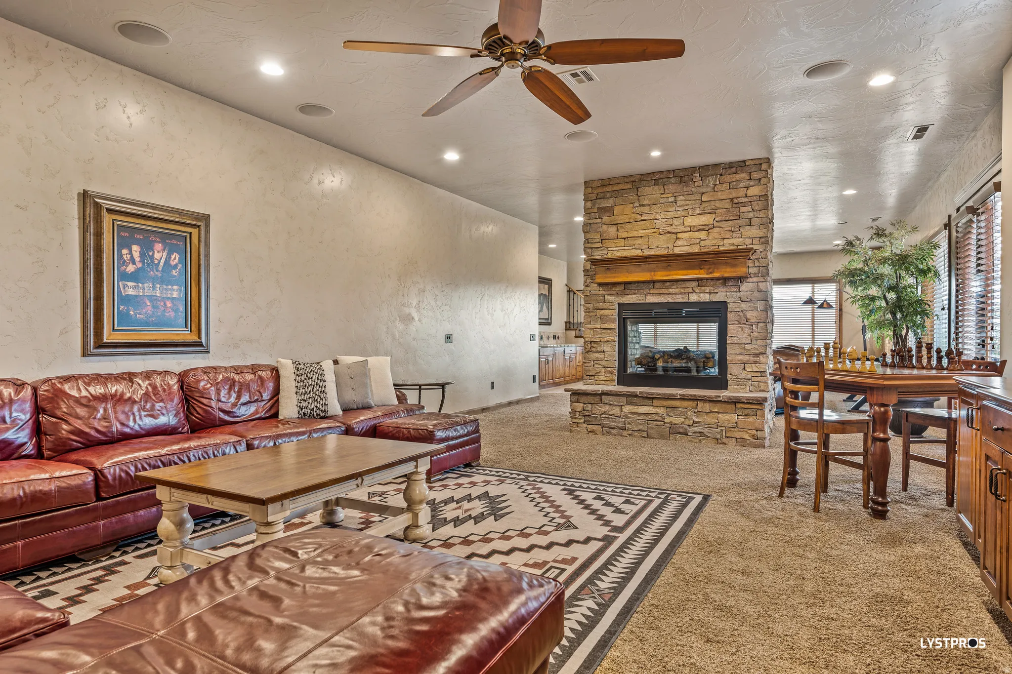 Living area featuring a fireplace, light carpet, ceiling fan, and recessed lighting