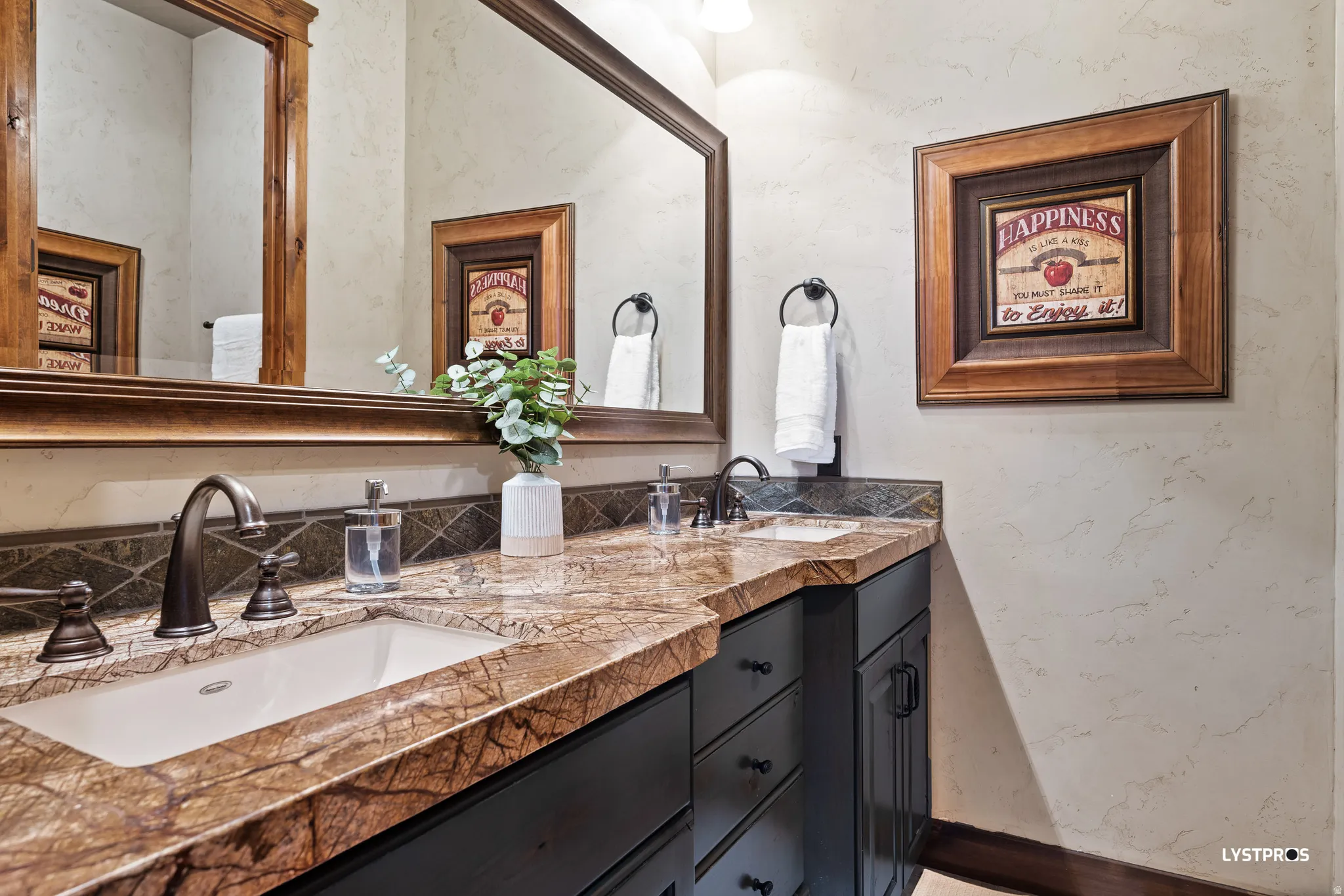 Bathroom featuring double vanity and a textured wall