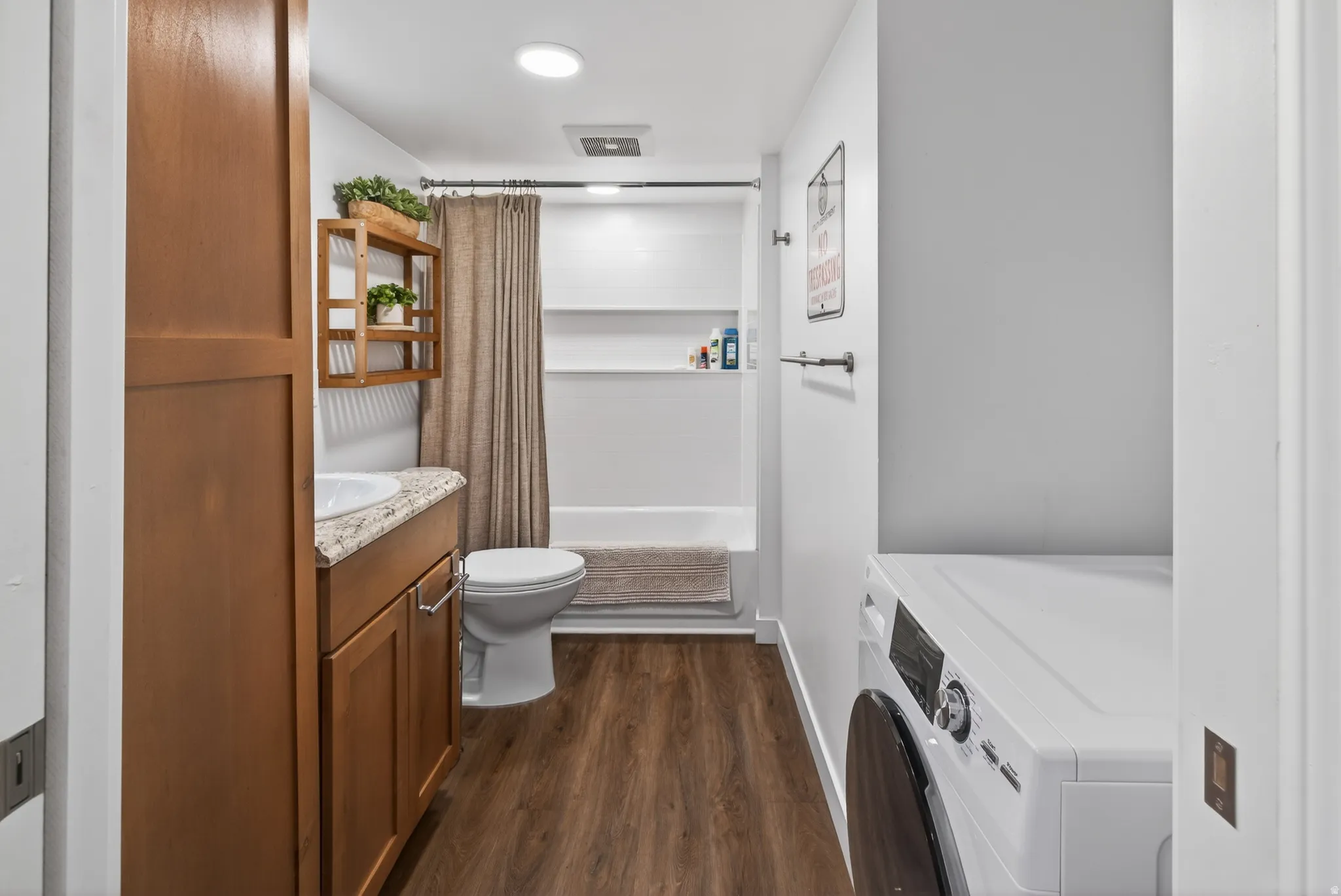Bathroom featuring vanity, dark wood-type flooring, and shower / bath combo