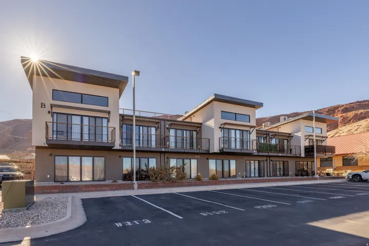 View of building exterior with uncovered parking and a mountain view