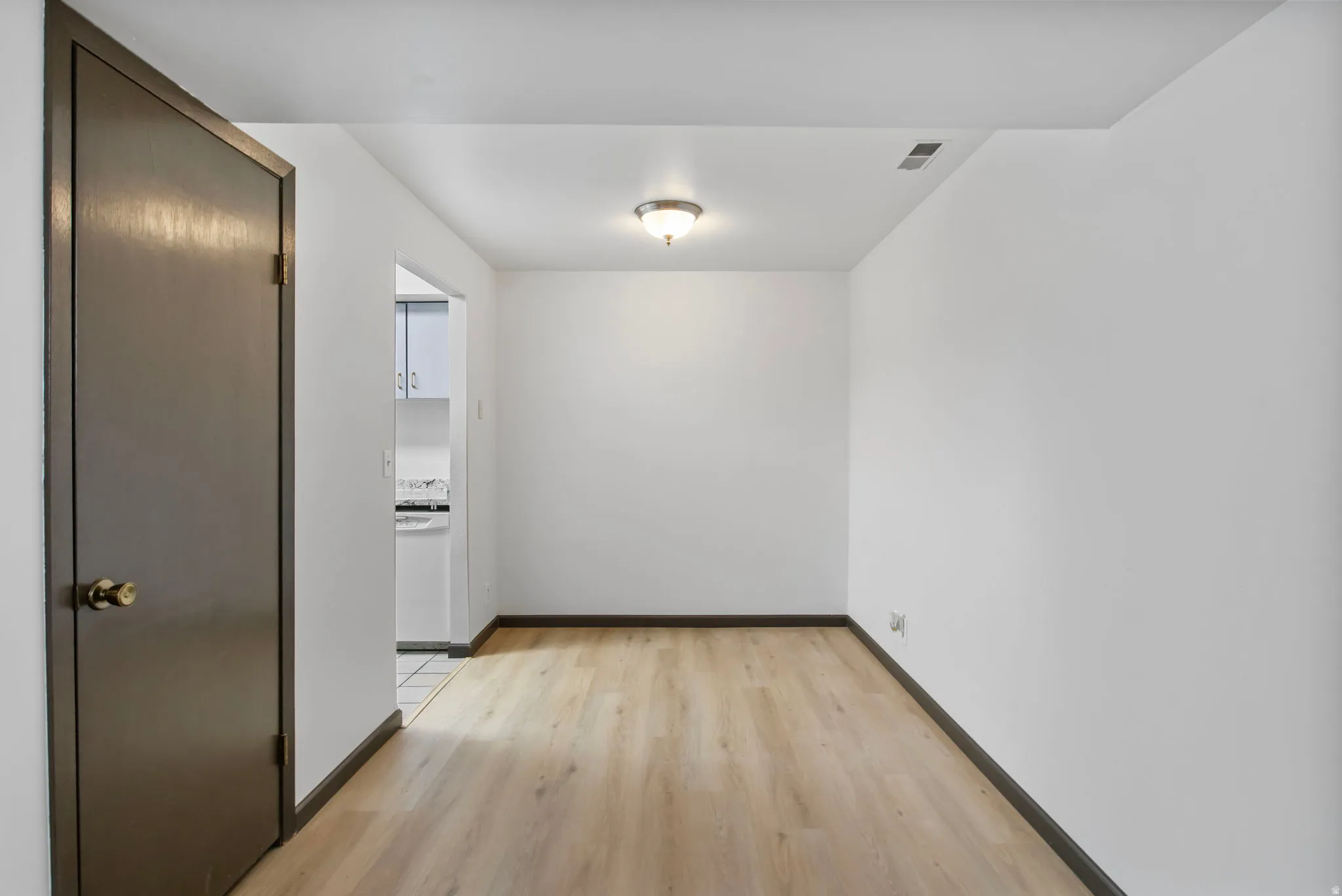 Unfurnished room with light wood-type flooring and baseboards