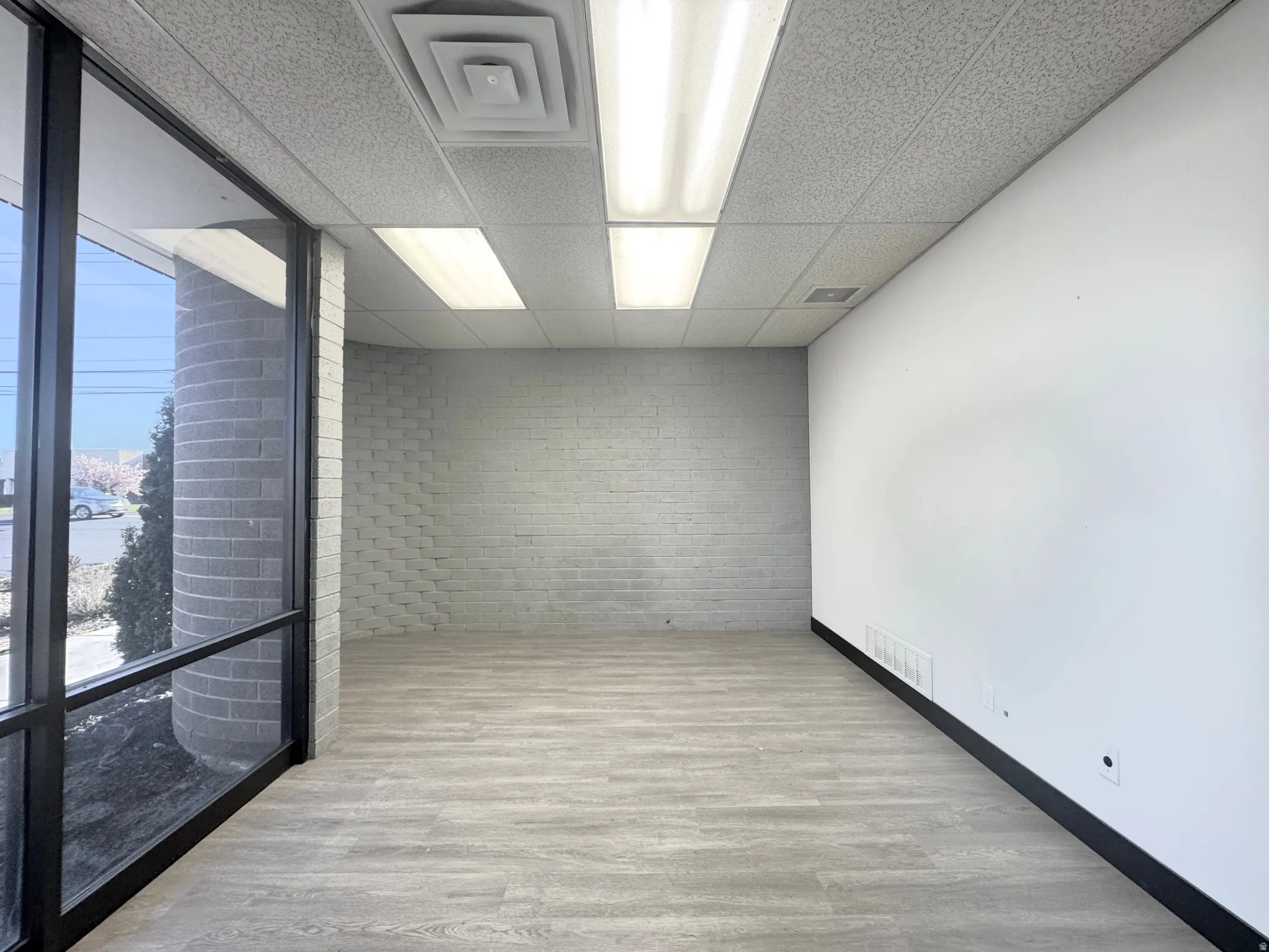 Unfurnished room with a paneled ceiling and light wood finished floors