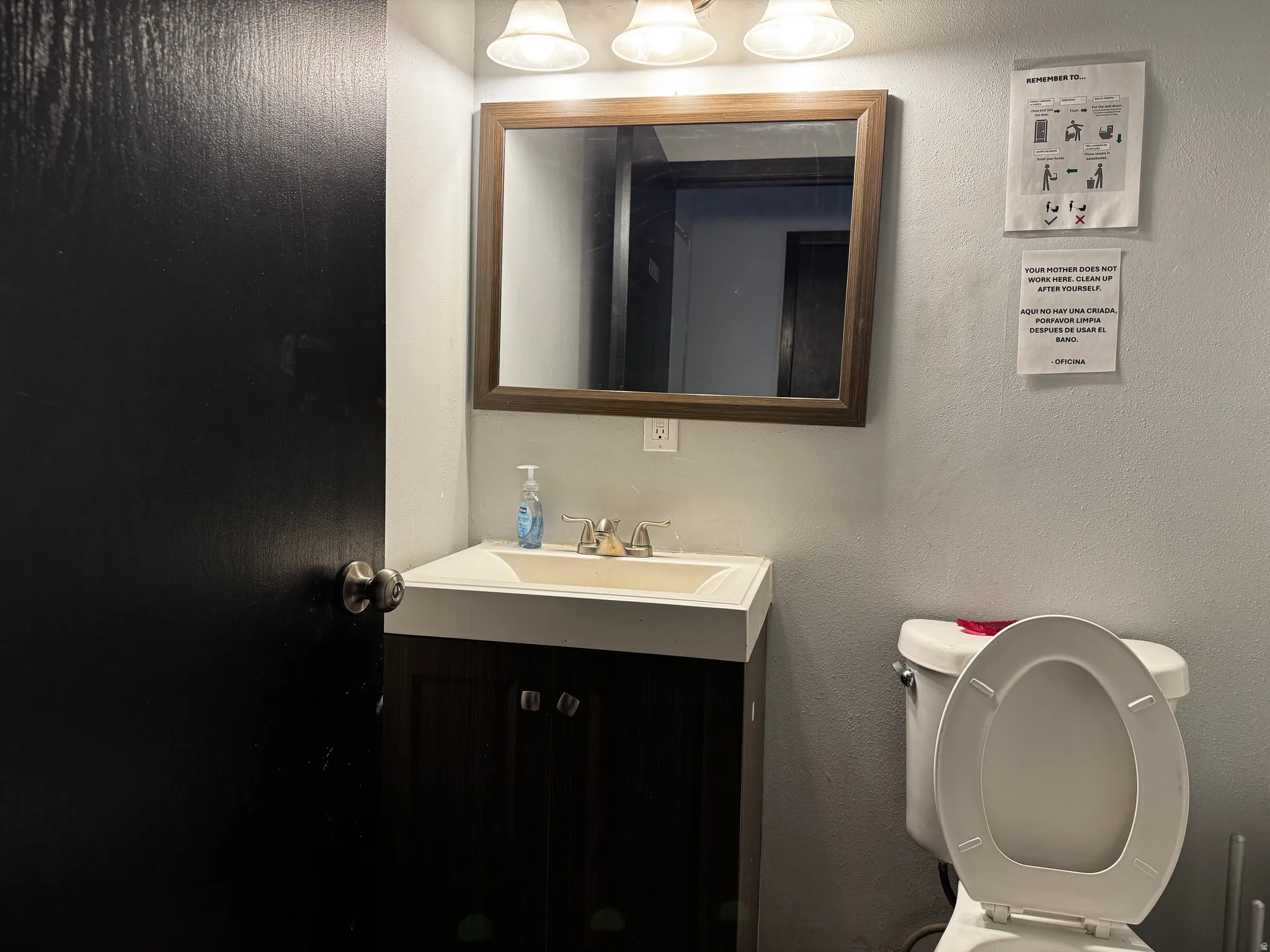 Half bathroom featuring a textured wall and vanity