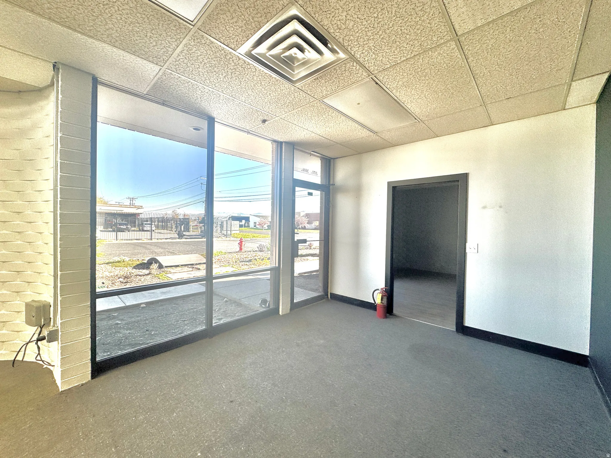 Spare room featuring a paneled ceiling and dark colored carpet