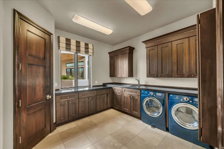 Washroom featuring cabinet space, independent washer and dryer, and light tile patterned flooring
