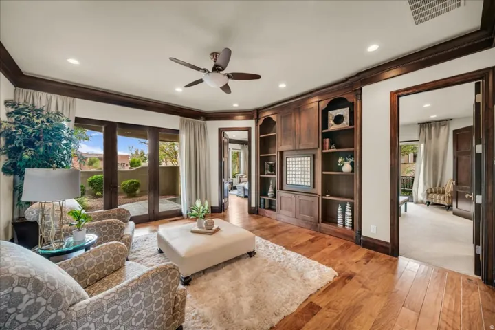 Living room with light wood finished floors, ceiling fan, ornamental molding, and recessed lighting