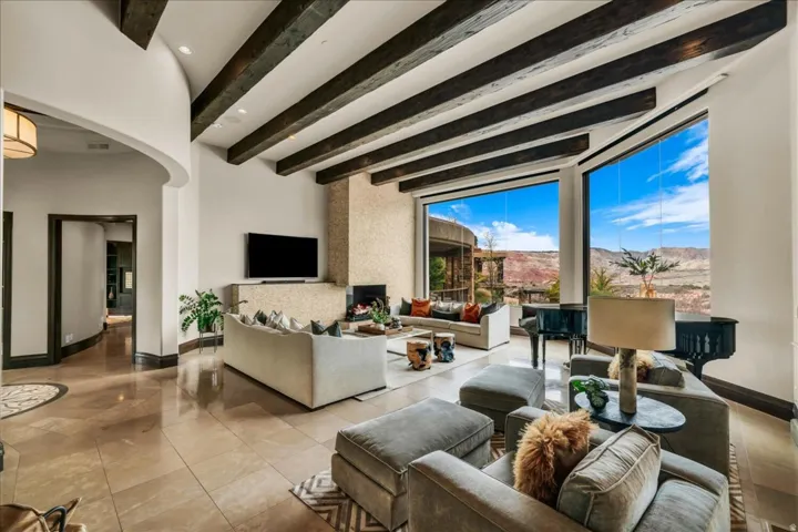 Living area featuring arched walkways, beam ceiling, and recessed lighting