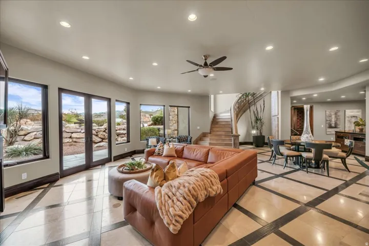 Living area featuring inlaid floor details, recessed lighting, a ceiling fan, stairs, and french doors