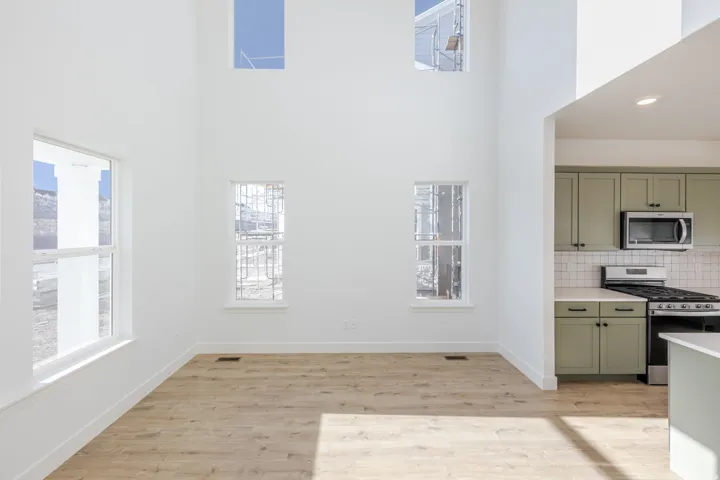 Open-concept living area with soaring ceilings and light wood-finish flooring