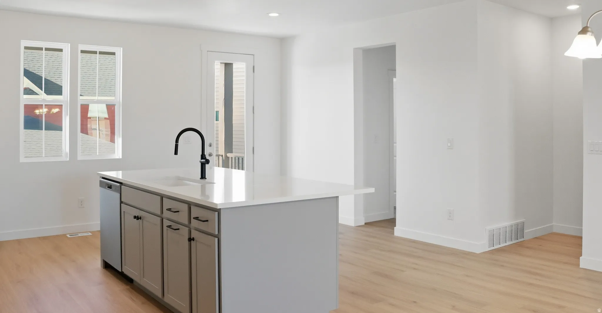 Kitchen with gray cabinets, recessed lighting, a kitchen island with sink, light wood finished floors, and stainless steel dishwasher