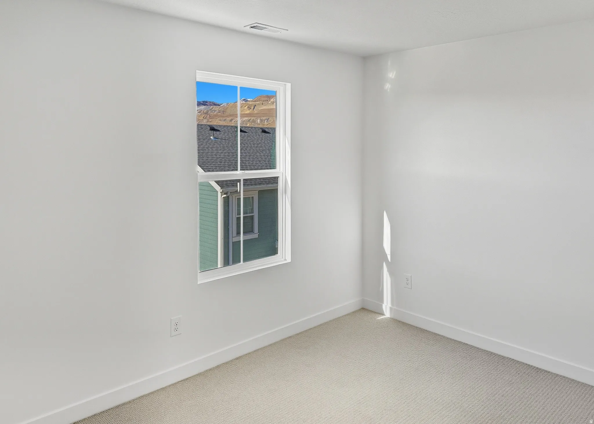 Carpeted spare room with baseboards