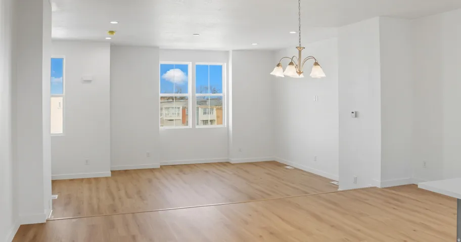 Unfurnished dining area with light wood finished floors, a chandelier, and recessed lighting