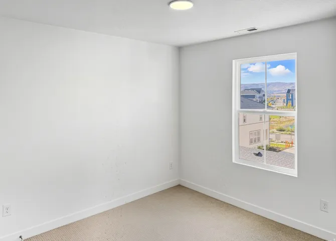 Carpeted empty room featuring baseboards