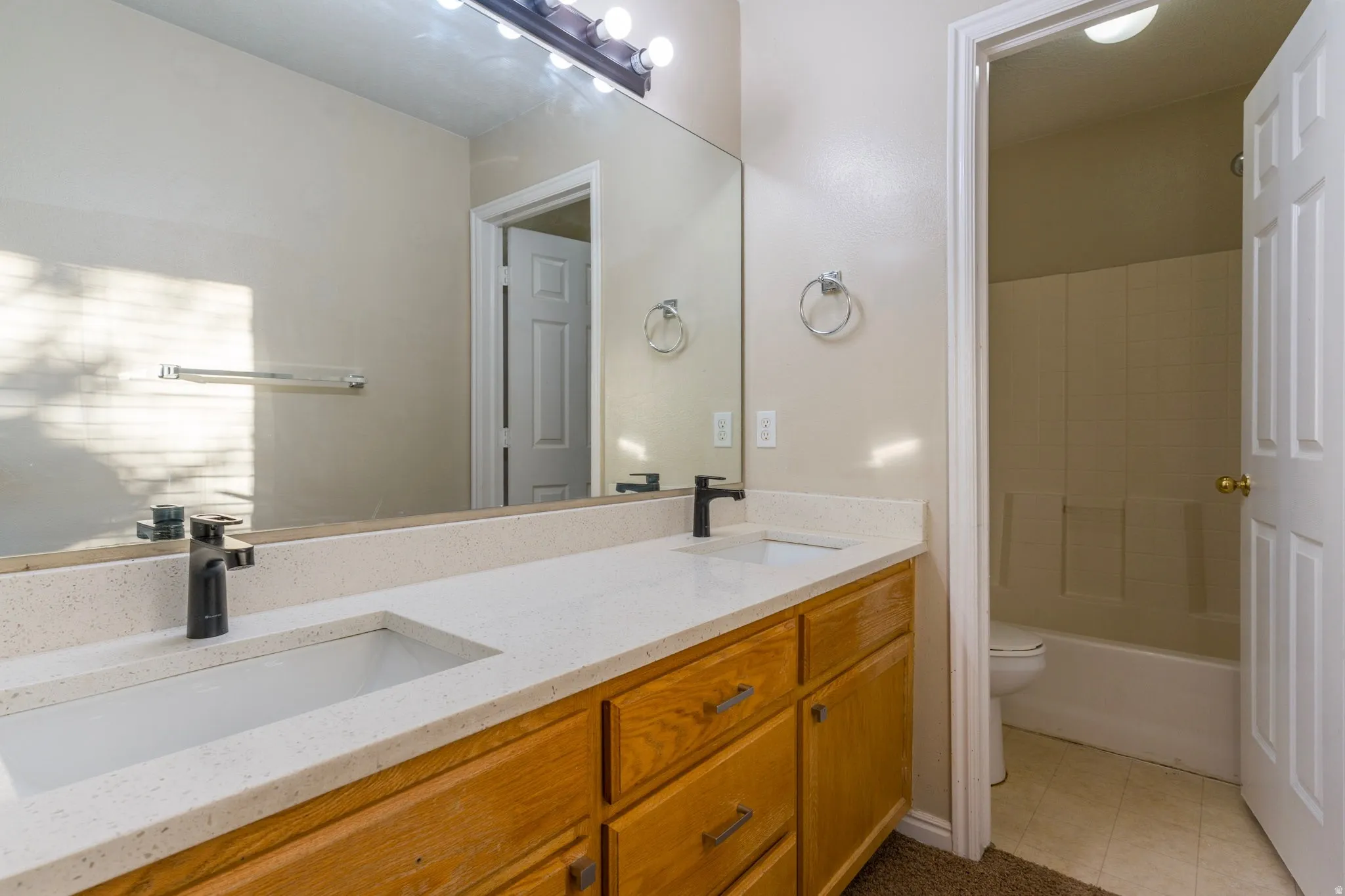 Full bathroom with double vanity and tub / shower combination