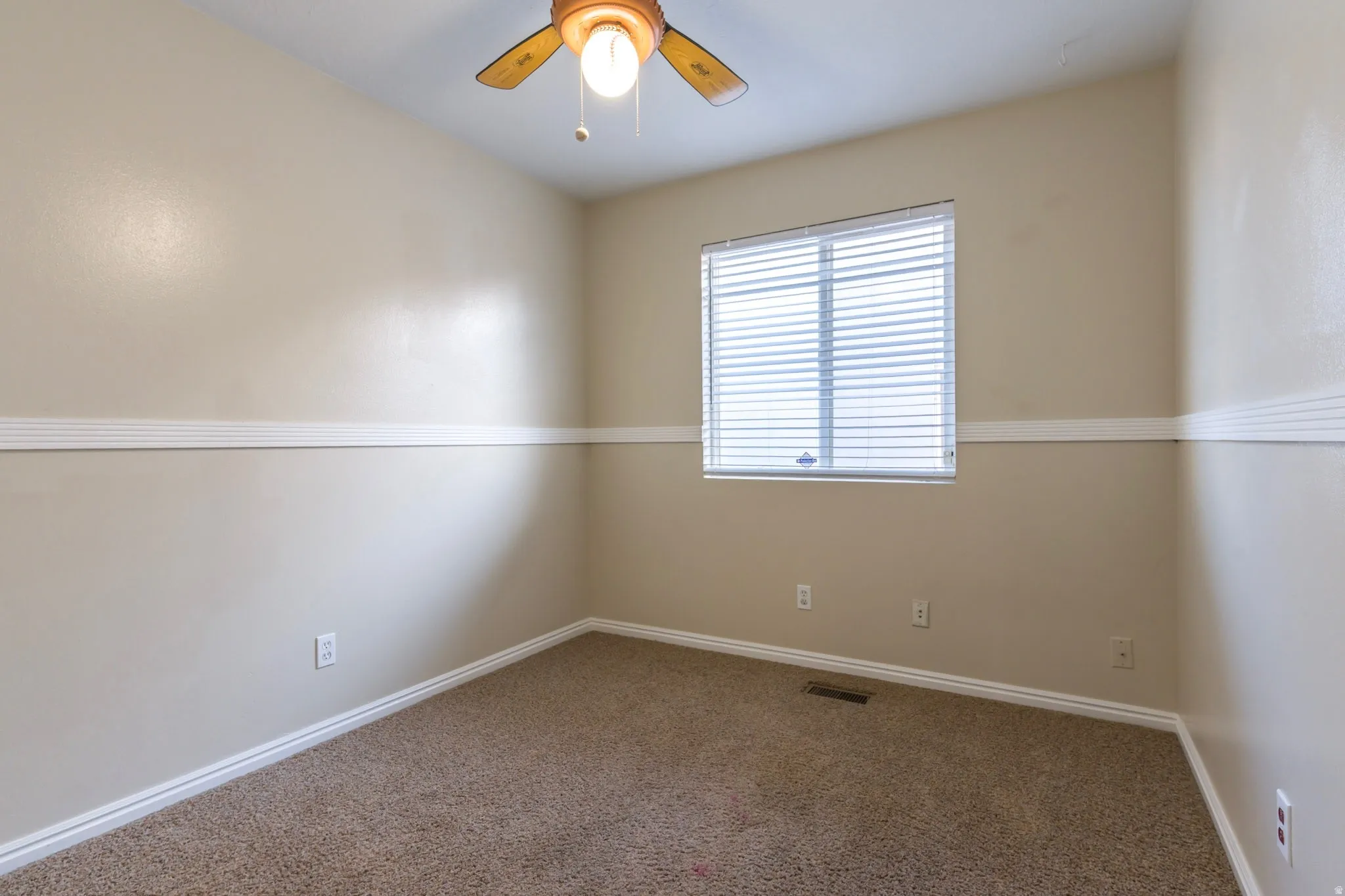 Spare room featuring carpet floors and ceiling fan