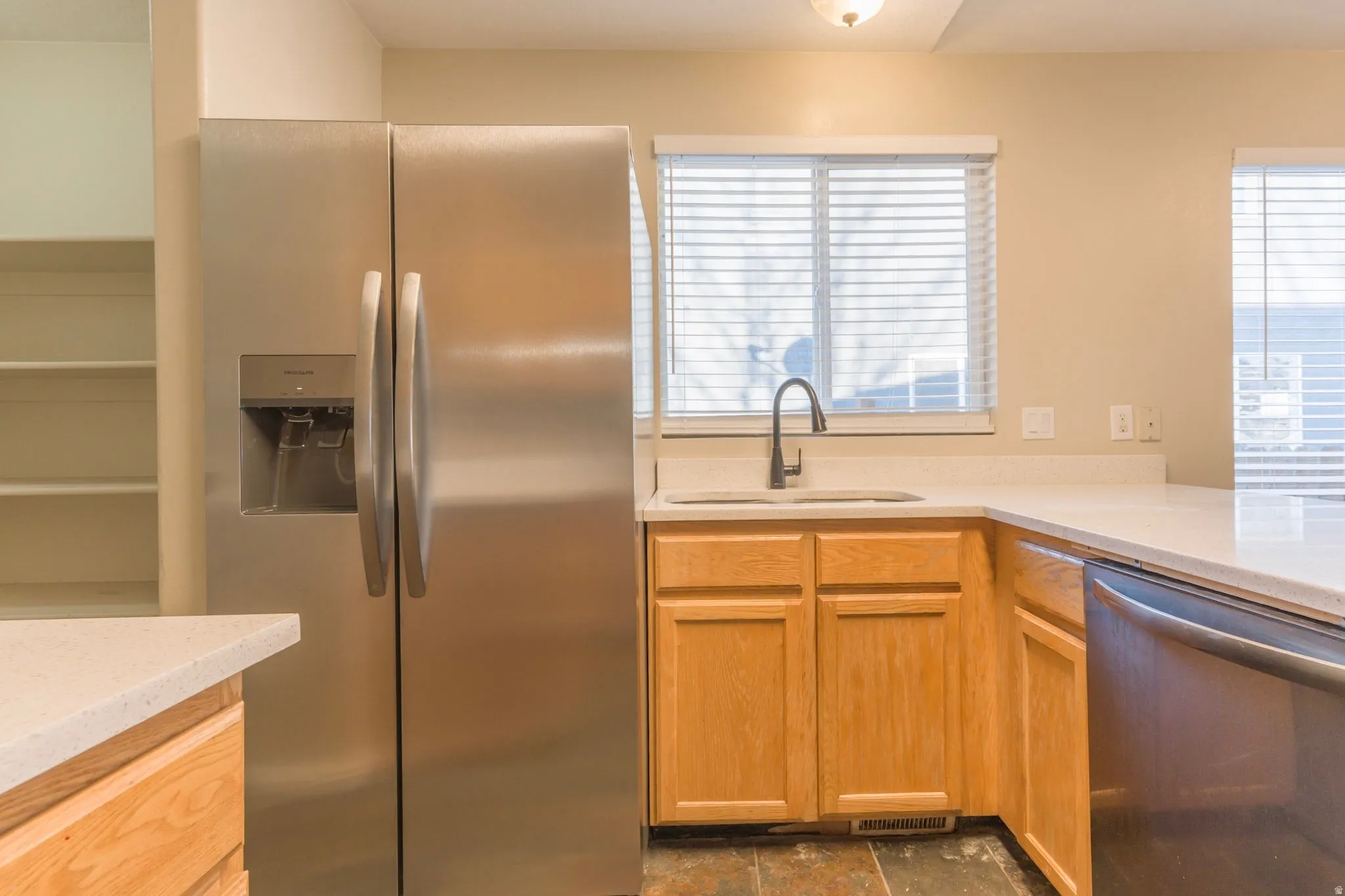 Kitchen with stainless steel appliances and light stone countertops