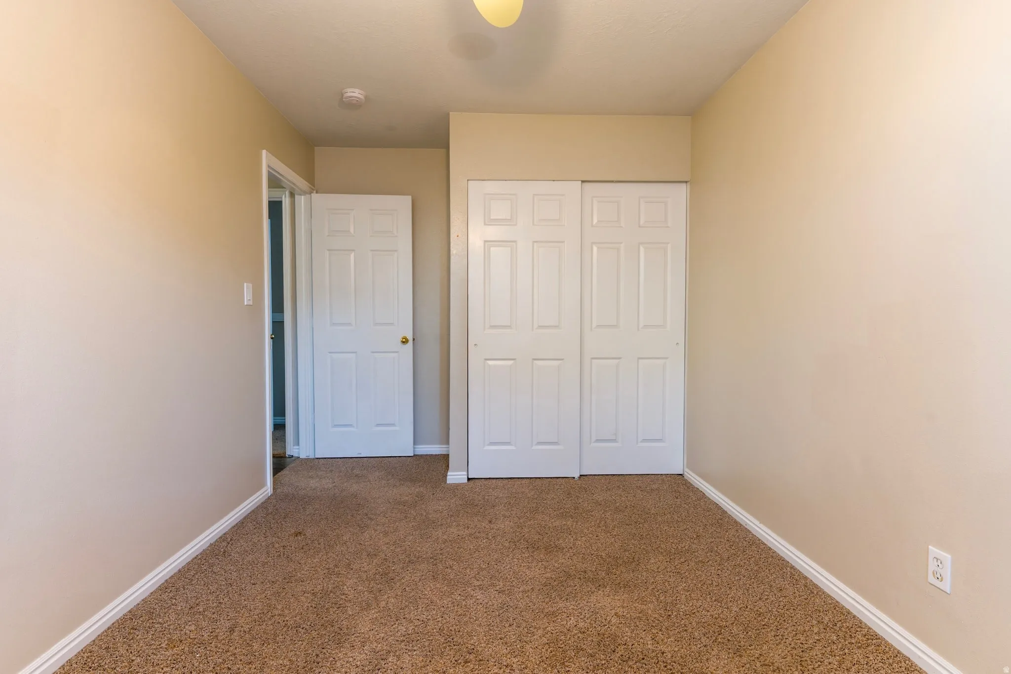Unfurnished bedroom featuring carpet, a closet, and ceiling fan