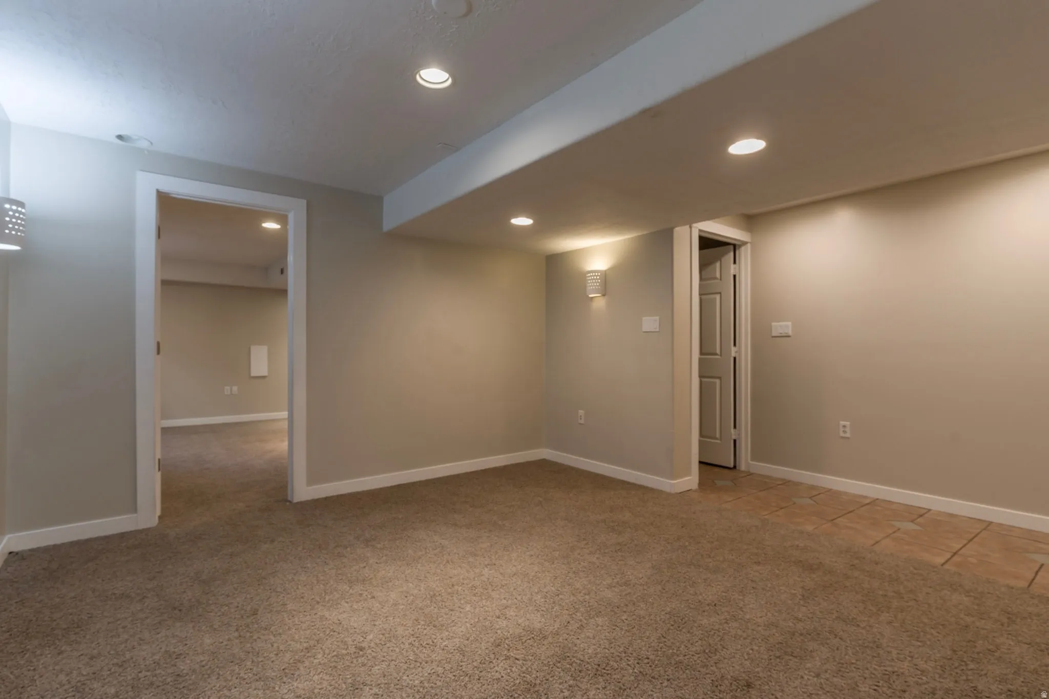 Basement with light colored carpet and recessed lighting