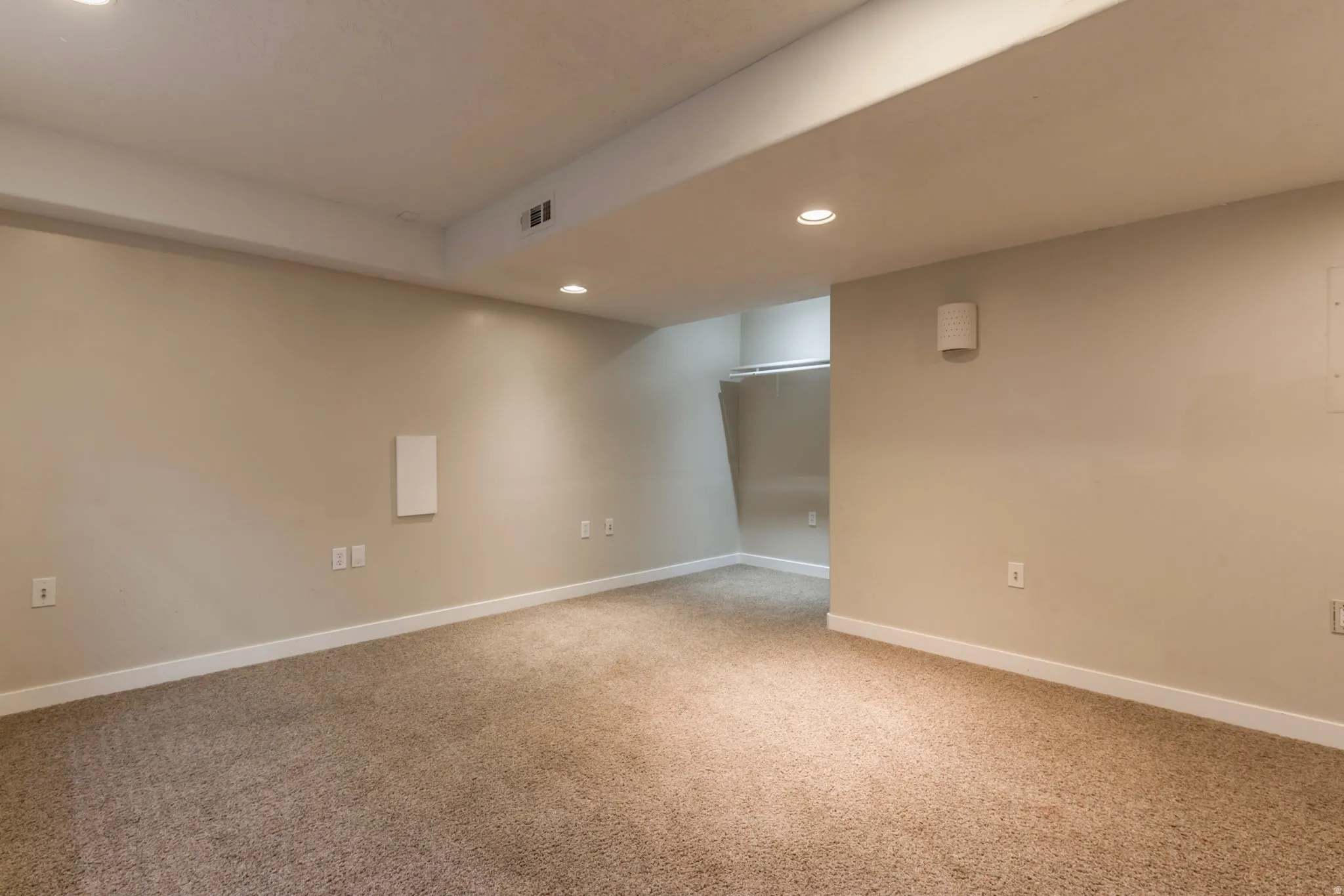 Empty room with recessed lighting and light colored carpet