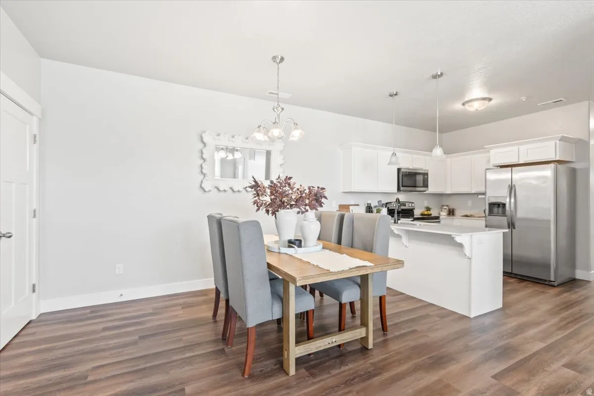 Dining area with a chandelier and dark wood finished floors